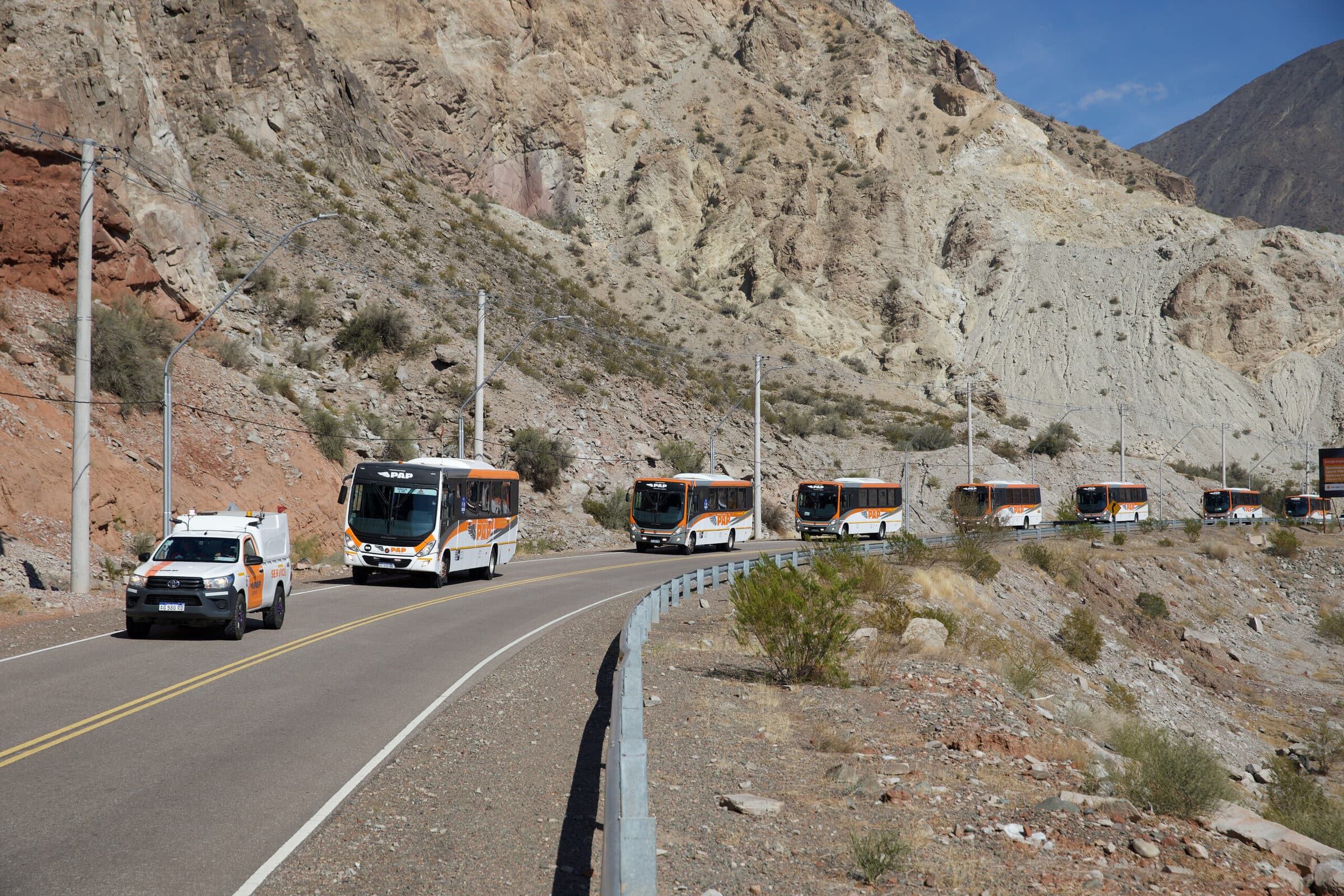 Convoy de buses PAP encabezado por una camioneta PAP en una ruta de montaña