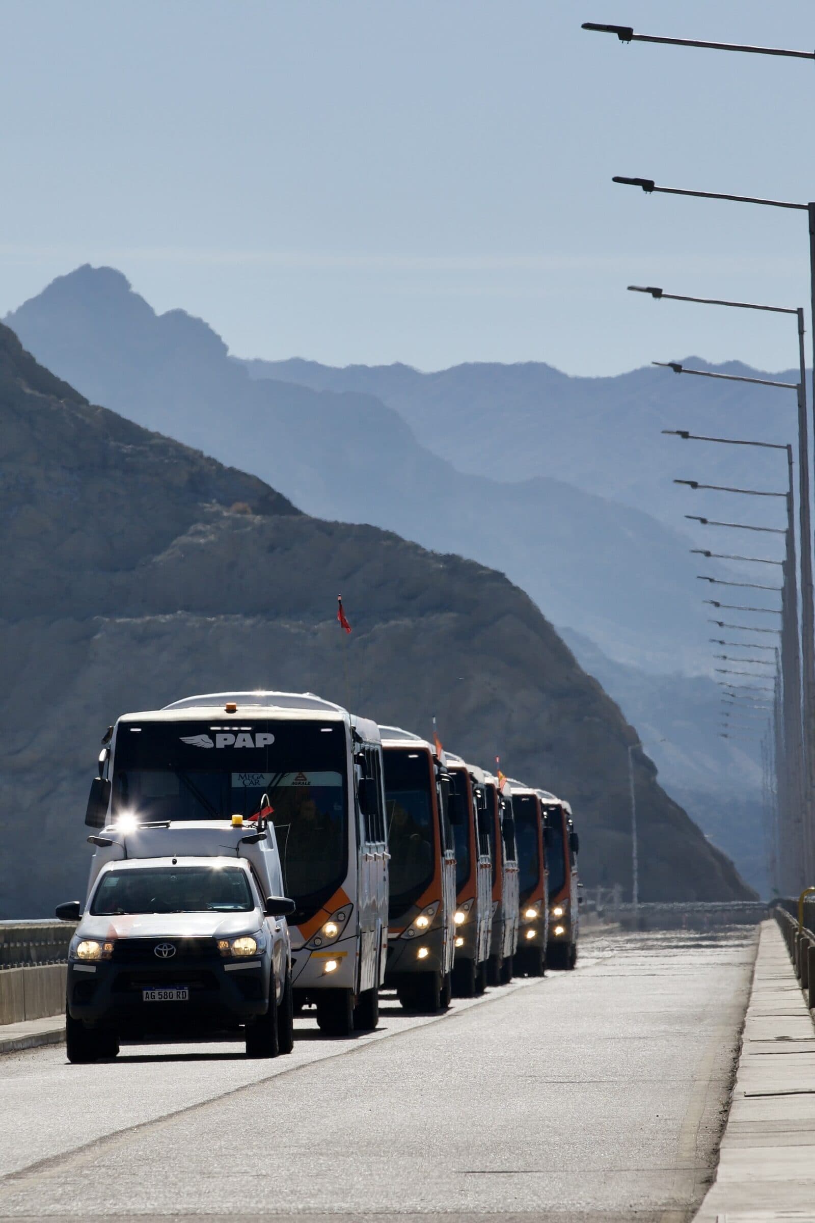 Convoy de buses PAP con camioneta avanzando por una ruta de montaña